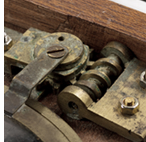 Brass gears and linkages in a mahogany frame.