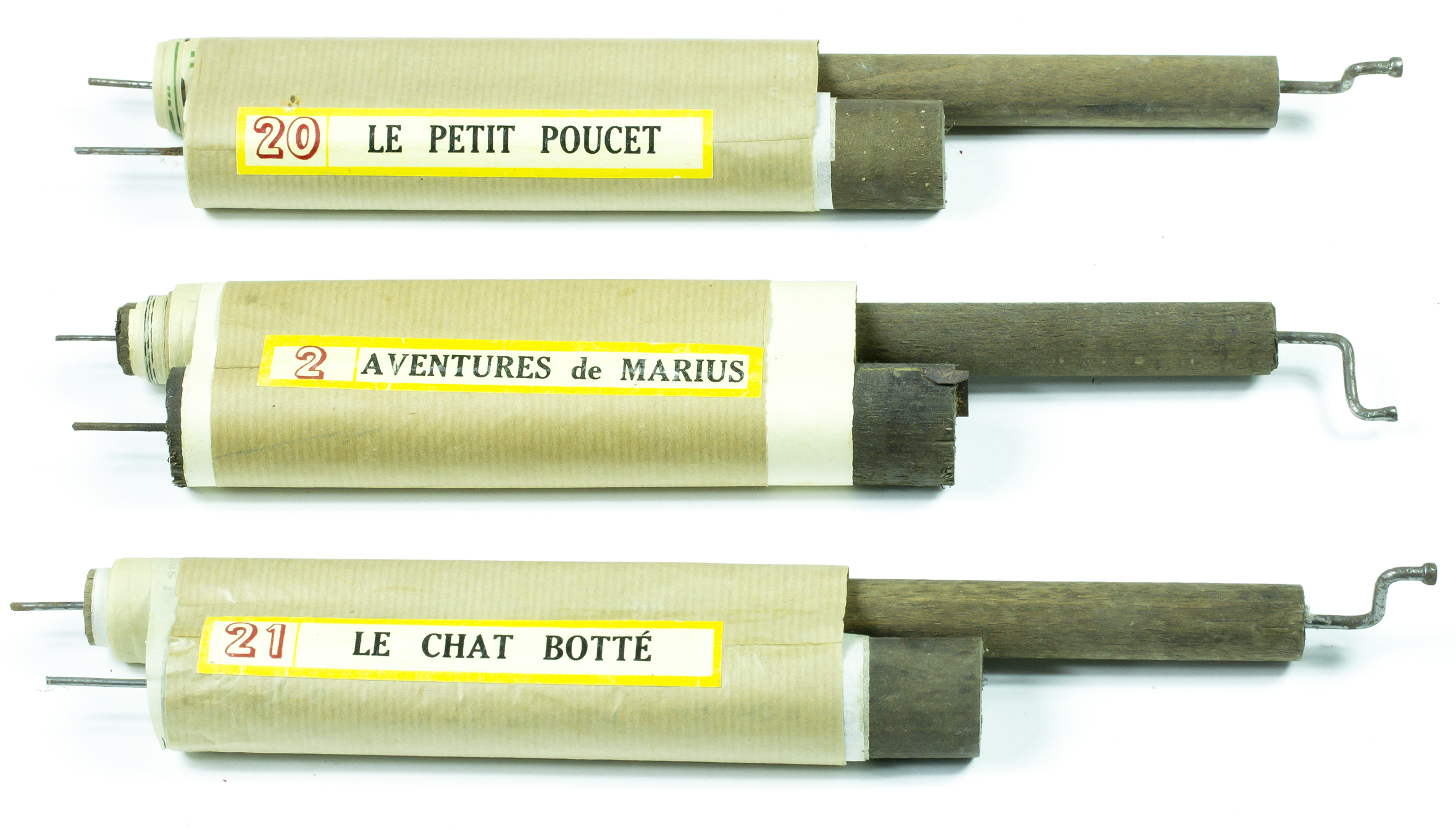 Three scrolls with wooden spools in paper wrappers with labels